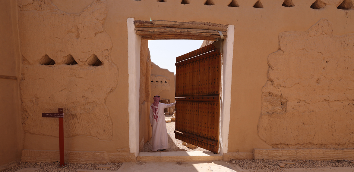 env: At‑Turaif（UNESCO）泥砖建筑与城门（Bujairi Terrace 附近景观）